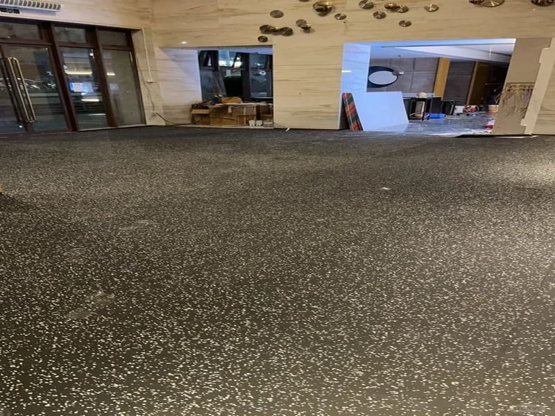 worker applying polyurethane adhesive with a square notch trowel